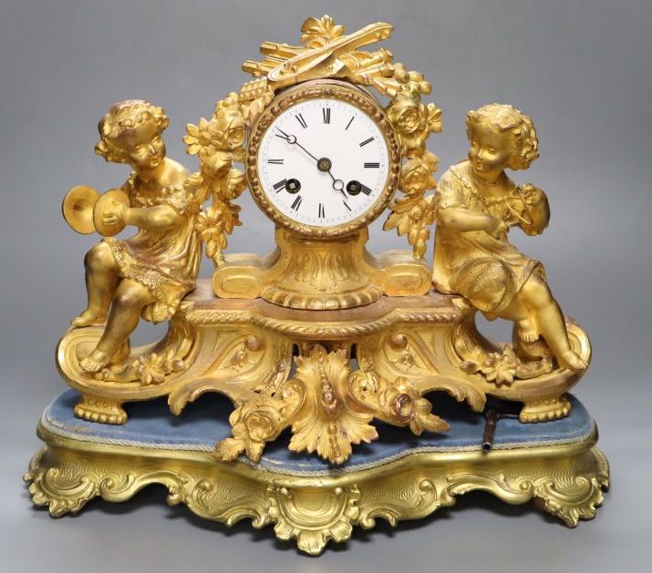 A 19th century French ormolu and gilt metal mantel clock, with musical youth surmount, Vincenti bell striking movement, on giltwood pli